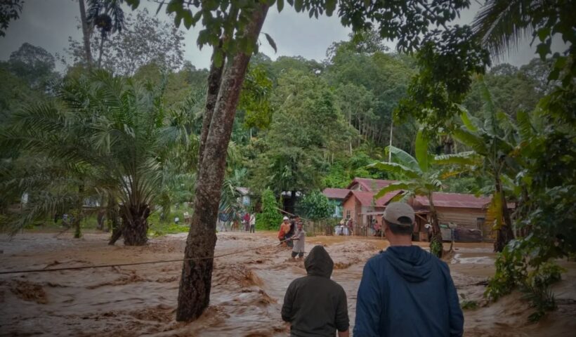 warga menerjang arus banjir di banjir sumatera